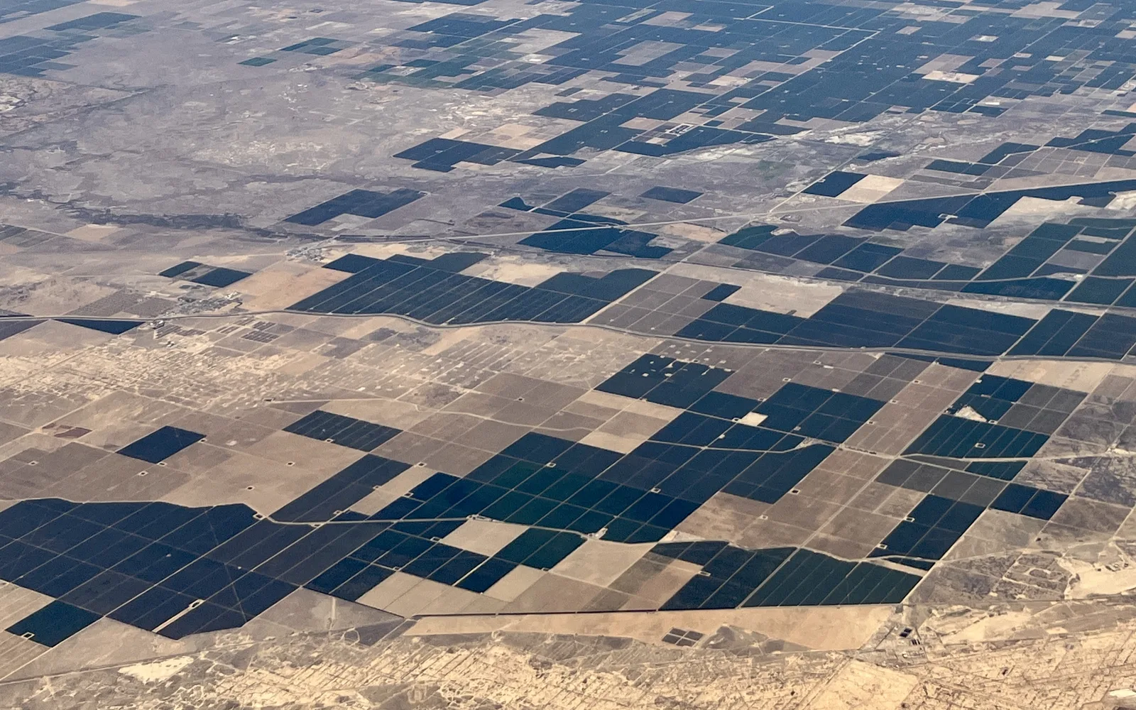 Aerial view of extensive agricultural fields in California's Central Valley showing the patchwork of farming operations